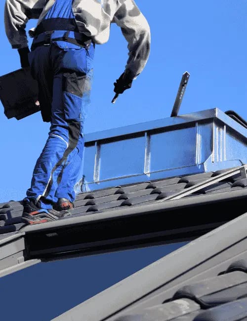 general contractors repairing roof under blue sky by roofing contractors